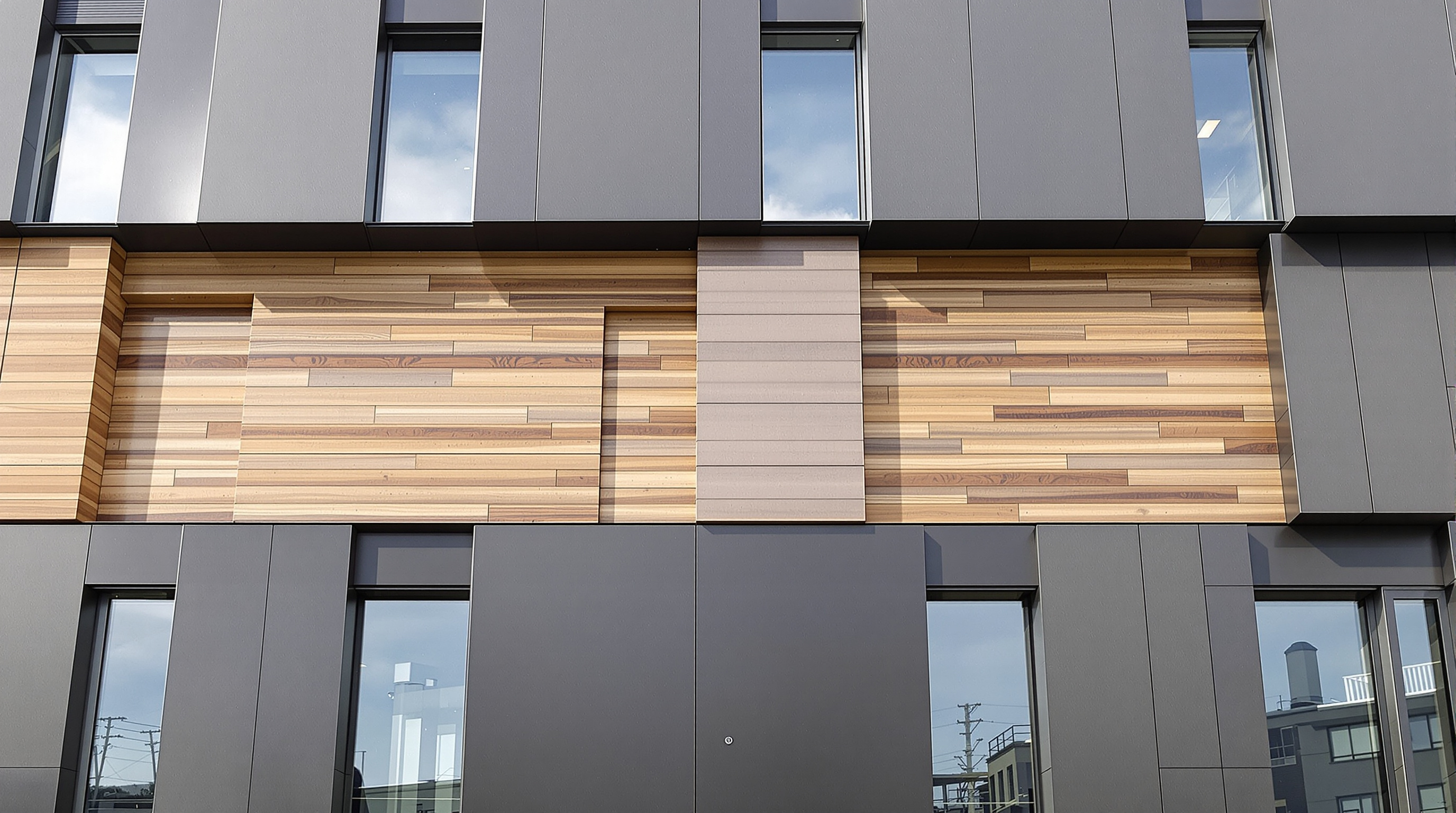 Façade moderne avec panneaux Trespa Meteon multicolores et décors bois