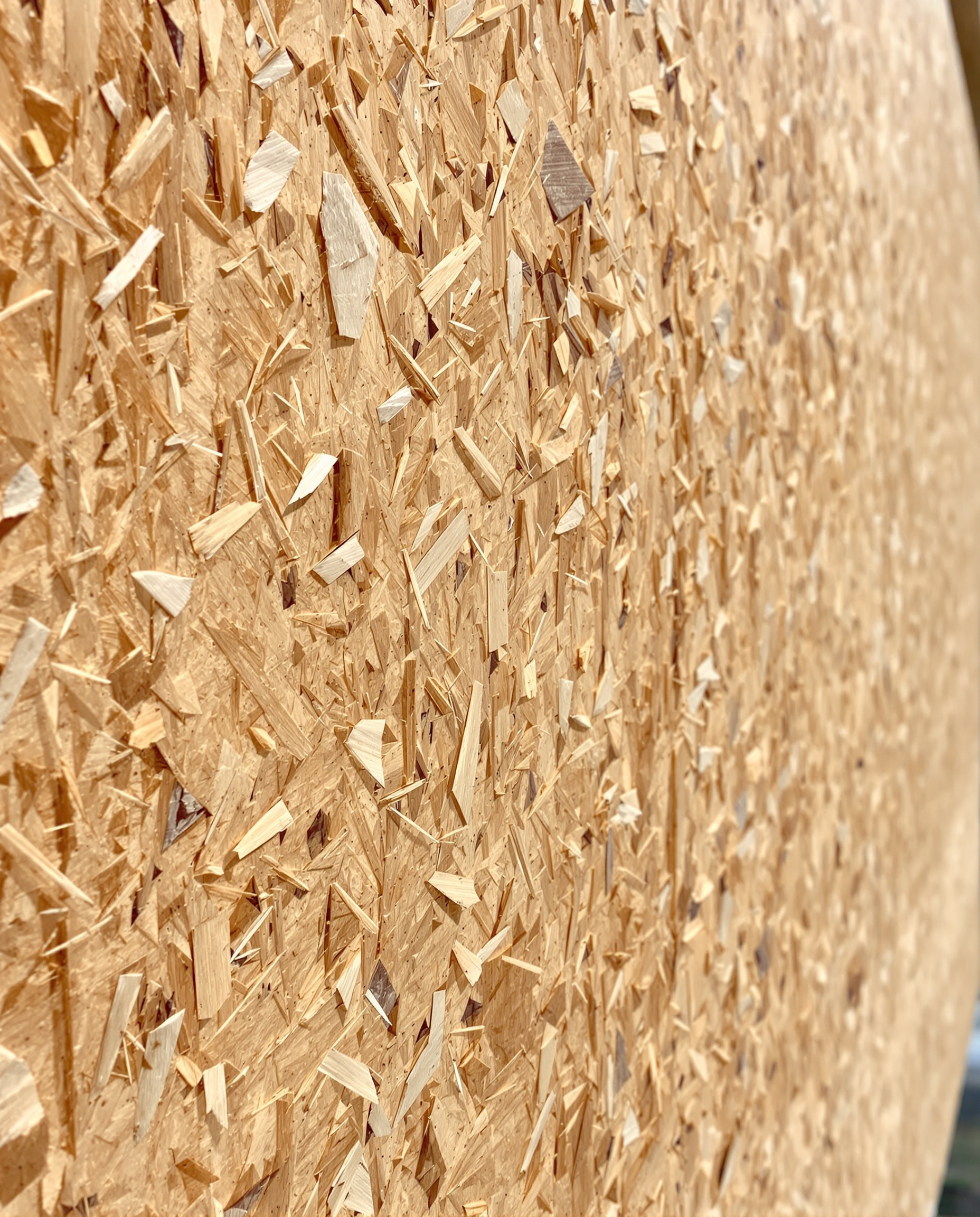 Gros plan sur OSB brut montrant ses lamelles – structure caractéristique du matériau.
