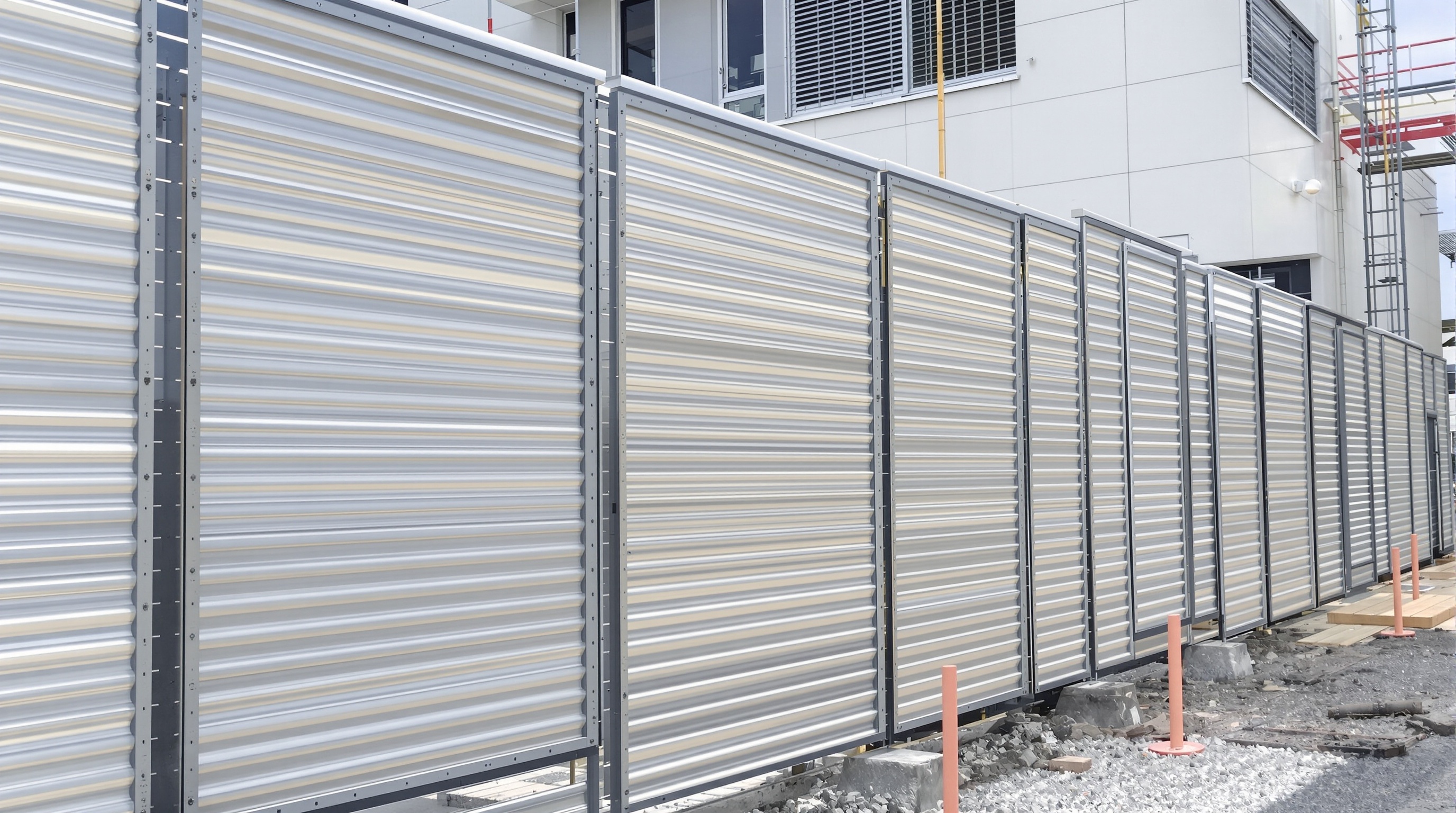 Panneaux aluminium installés en extérieur sur une clôture moderne, une façade ventilée et un brise-vue contemporain.
