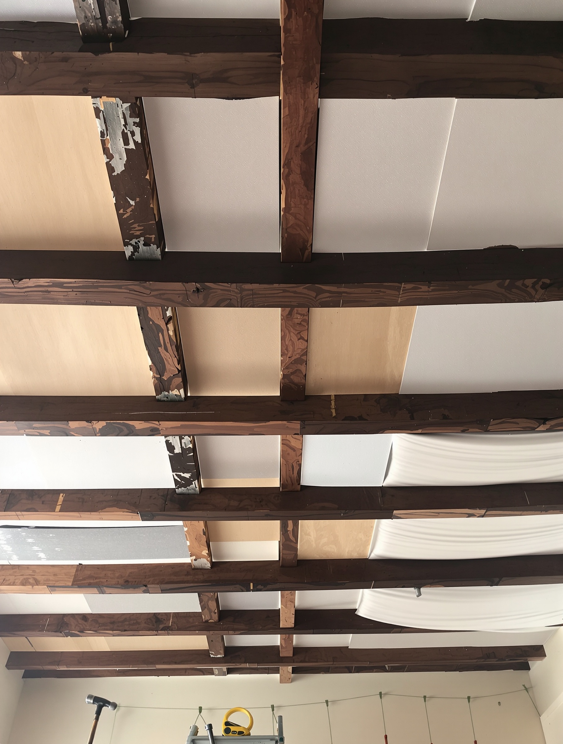 Habillage moderne d'un plafond ancien entre poutres bois avec différents matériaux